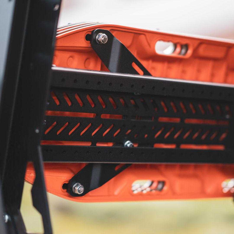 Load image into Gallery viewer, Close-up of TracMOUNT Maxtrax Mount securely attached to orange recovery board on vehicle rack